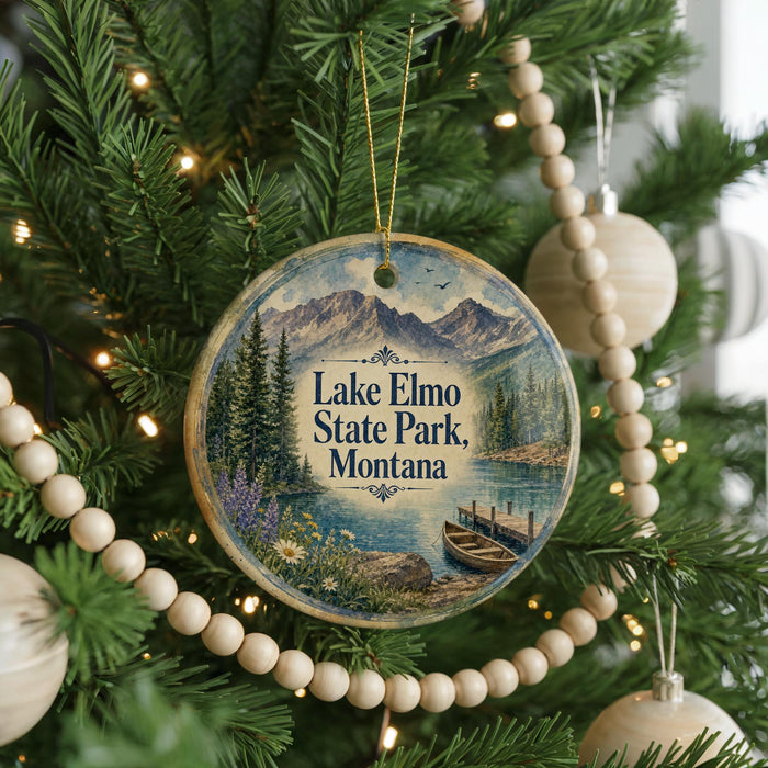 A circular ornament hanging on a Christmas tree, featuring a scenic image of Lake Elmo State Park, Montana.