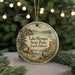 A round ornament with a scenic landscape of Lake Herman State Park, South Dakota, featuring a bird, pine trees, and a lake.