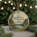 A round ornament with a scenic image of Lake Hiddenwood State Recreation Area in South Dakota, featuring a lake, pine trees, and a cabin.