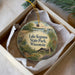 A decorative ornament in a box, featuring a scenic image of Lake Kegona State Park, Wisconsin.