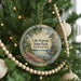 A round ornament hanging on a Christmas tree, featuring a scenic view of Lake Norman State Park in North Carolina.