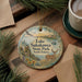 A decorative ornament with a scenic image of Lake Sakakawea State Park, North Dakota, featuring a deer, a bird, and a sunset.