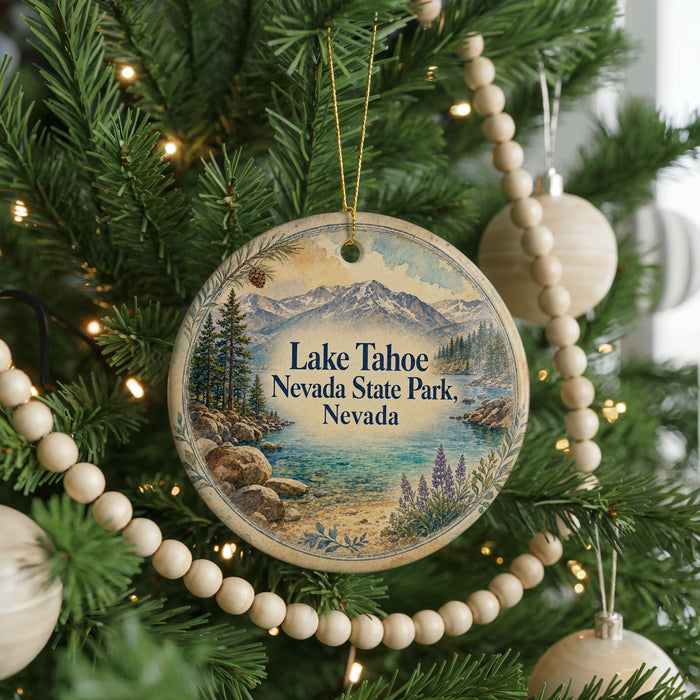 A round ornament hanging on a Christmas tree, featuring a scenic landscape with mountains, pine trees, and a lake.