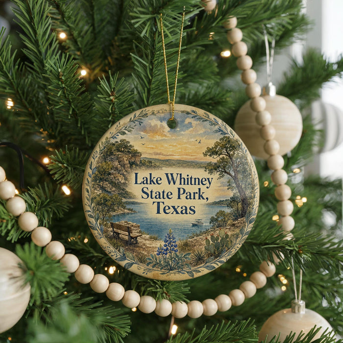 A round ornament hanging on a Christmas tree, featuring a scenic landscape of Lake Whitney State Park, Texas.