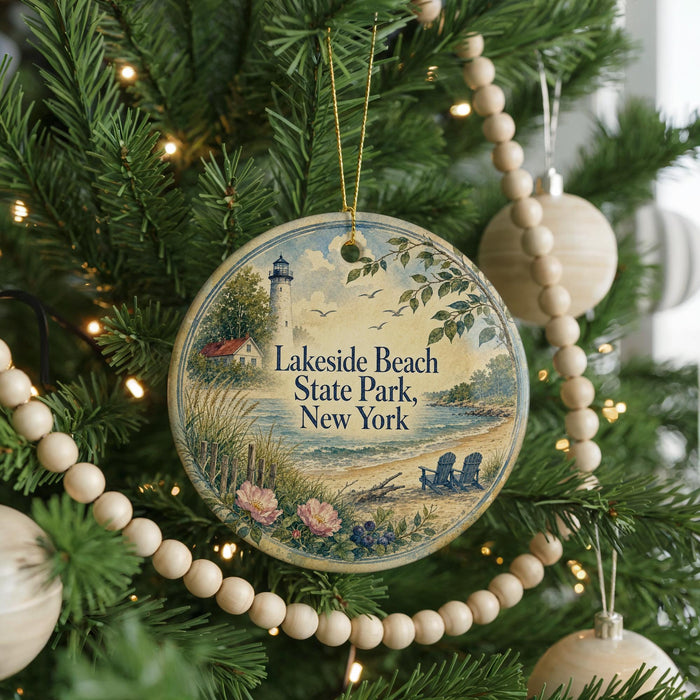 A round ornament hanging on a Christmas tree, featuring a lighthouse and a beach scene with a message that reads "Lakeside Beach State Park, New York".