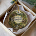 A circular ornament with a scenic image of Laurel Hill State Park in Pennsylvania, featuring a waterfall, cabin, and forest.