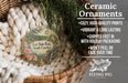 Ceramic ornaments, featuring a round ornament with a landscape scene and text, are displayed in a basket with greenery.