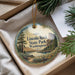 A decorative ornament with the text "Lincoln Rock State Park, Washington" on it, hanging from a string. The ornament is placed on a surface with pine branches and a white envelope visible in the background.
