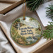 A decorative ornament with a scenic landscape of a lake, waterfall, and surrounding greenery, featuring a bird in flight.