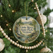 A round ornament on a Christmas tree, featuring a scenic image of Little River State Park in Vermont.