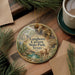 A circular ornament with a scenic image of the Longhorn Cave in Texas, featuring a cow and a natural landscape.
