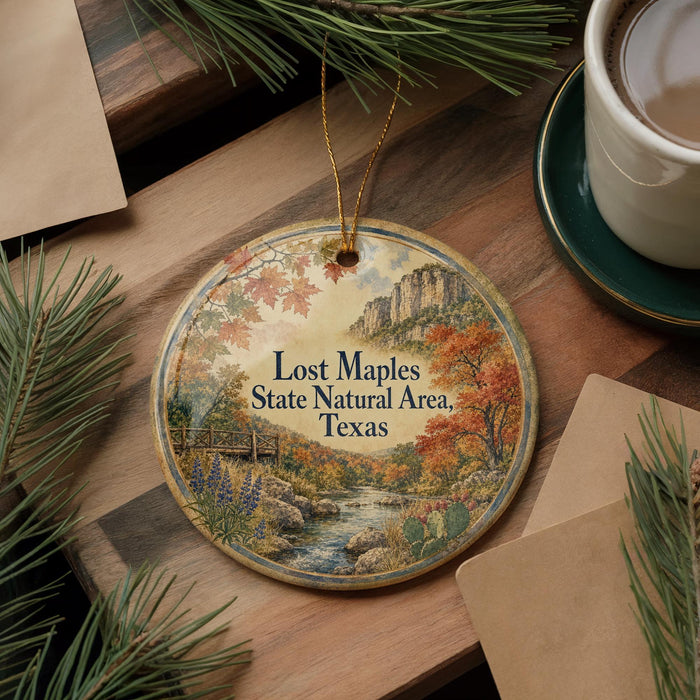 A decorative ornament with a scenic landscape of a river, mountains, and fall foliage, along with the text "Lost Maples State Natural Area, Texas".