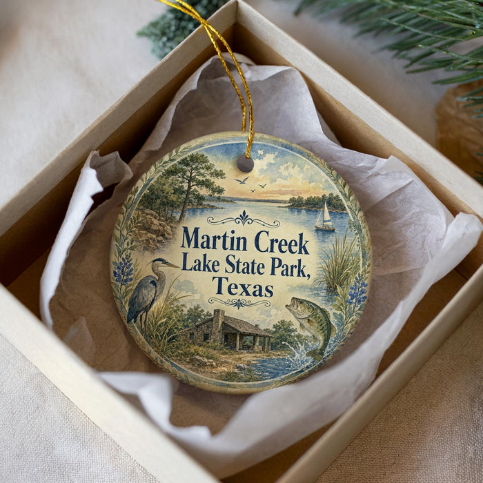 A decorative ornament in a box, featuring a scenic image of Martin Creek Lake State Park in Texas.