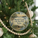 A round ornament hanging on a Christmas tree, featuring a scenic image of Martin Creek Lake State Park, Texas.