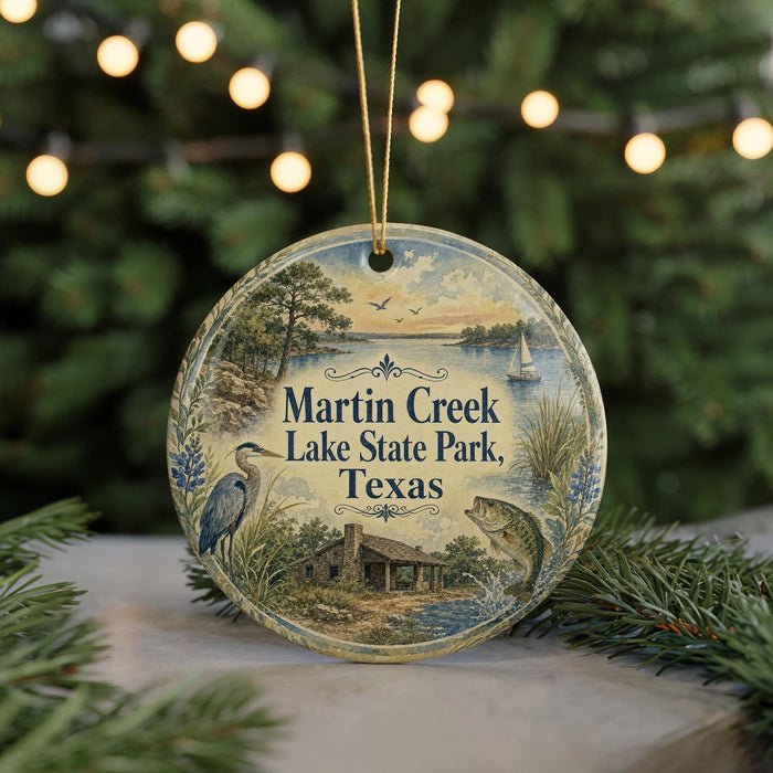 A round ornament with a painting of Martin Creek Lake State Park, Texas, featuring a bird, a house, and a boat on the lake.