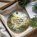 A decorative ornament with a scenic landscape featuring a lake, a lighthouse, and a bird, hanging from a string.