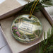 A decorative ornament featuring a scenic landscape of Pennsylvania State Park, with a river and pine trees.