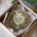 A round ornament with a scenic landscape of Meridian State Park, Texas, displayed in a box with a white tissue paper lining.
