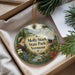 A decorative ornament with a woman in traditional clothing and a scenic landscape, including mountains, water, and pine trees, is displayed in a box.
