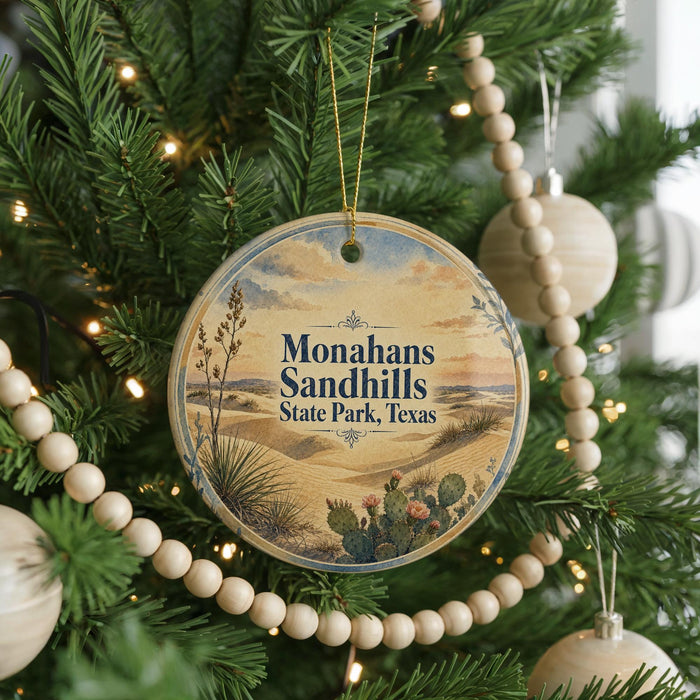 A round ornament on a Christmas tree, featuring a desert landscape with cacti and mountains in the background, and the text "Monahans Sandhills State Park, Texas" printed on it.