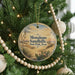 A round ornament on a Christmas tree, featuring a desert landscape with cacti and mountains in the background, and the text "Monahans Sandhills State Park, Texas" printed on it.
