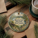 A decorative ornament featuring a scenic landscape of Moncove Lake State Park, West Virginia, with pine trees and a cabin in the background.