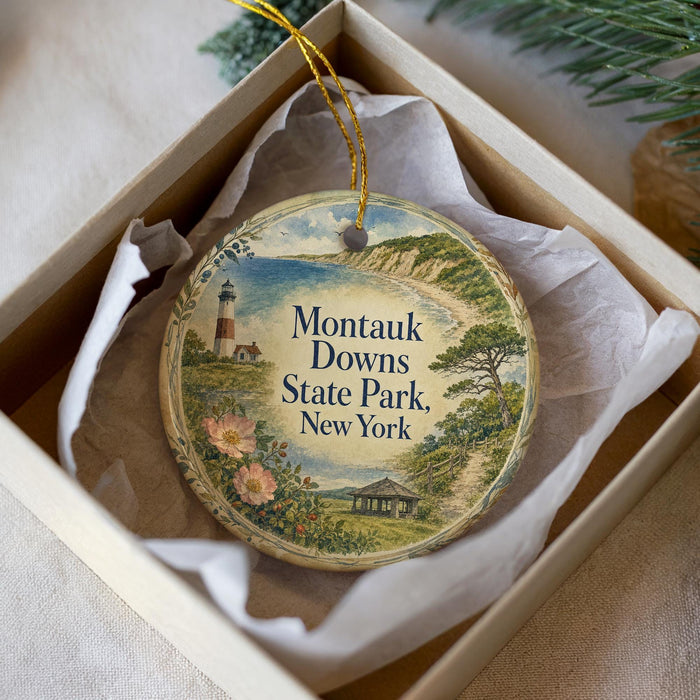A decorative ornament in a box, featuring a lighthouse and a scenic landscape, with the text "Montauk Downs State Park, New York" prominently displayed.