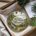 A decorative ornament with a scenic landscape of a waterfall and a cabin, hanging from a string.