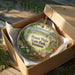 A decorative ornament in a brown box, featuring a scenic landscape of Mount Philo State Park in Vermont.