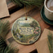 A round ornament with a scenic image of Mount Pisgah State Park, Pennsylvania, hanging on a wooden surface.