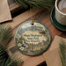 A decorative ornament featuring a scenic mountain landscape with a train, surrounded by pine branches and pine needles. The ornament has the text "Mount Washington State Park, New Hampshire" printed on it.