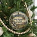 A round ornament hanging on a Christmas tree, featuring a scenic image of Mount Washington State Park in New Hampshire.