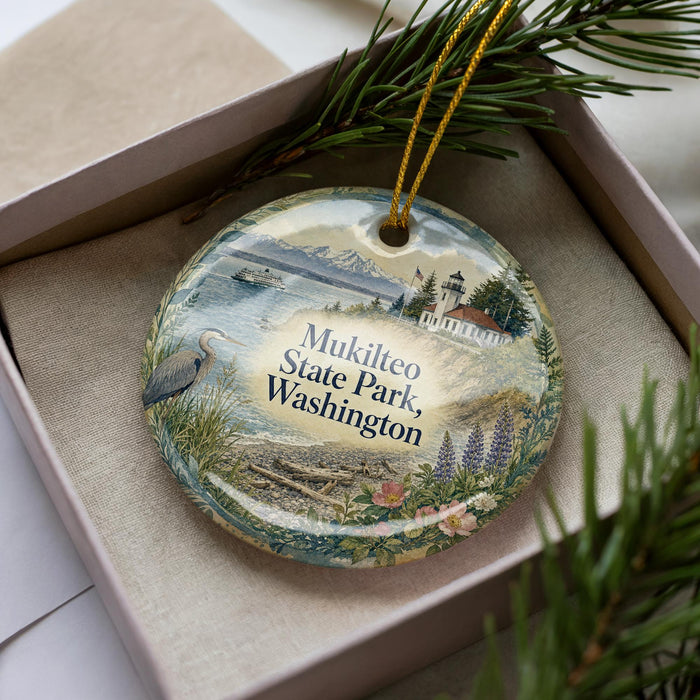 A decorative ornament in a box, featuring a scenic image of Mukilteo State Park in Washington.