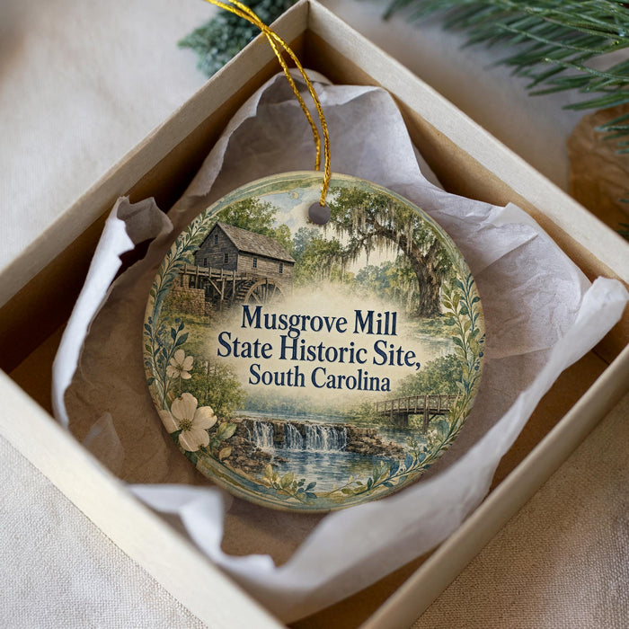 A round ornament with a painting of a historic site, specifically Musgrove Mill, South Carolina, displayed in a box.