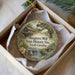 A round ornament with a painting of a historic site, specifically Musgrove Mill, South Carolina, displayed in a box.