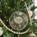 A round ornament hanging on a Christmas tree, featuring a scenic image of the Natural Bridge State Park in Virginia.