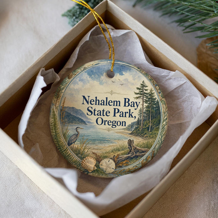 A decorative ornament in a white box, featuring a scenic landscape with a lake, mountains, and wildlife.