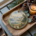 A decorative ornament with a scenic landscape of Nehalem Bay State Park, Oregon, featuring a bird, pine cones, and a candle on a wooden tray.