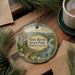 A decorative ornament featuring a scenic landscape of New River State Park in North Carolina, with a small boat on a river and a bridge in the background.