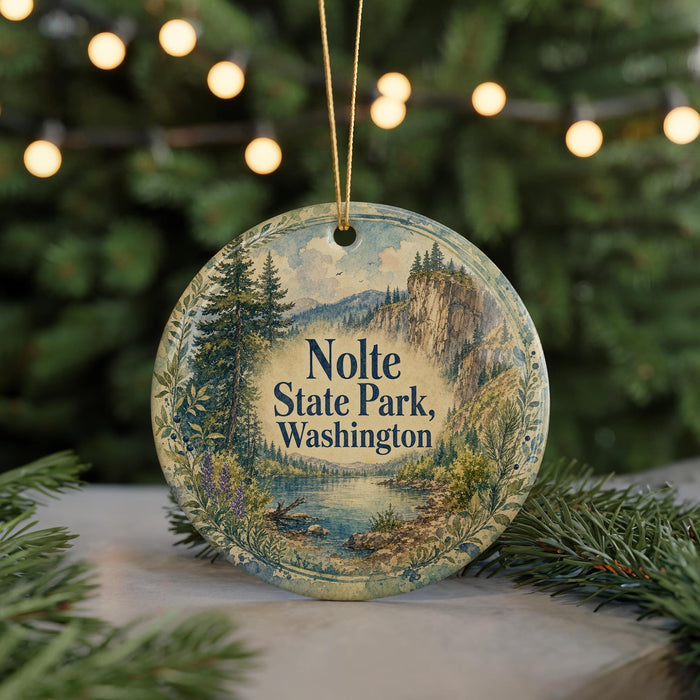 A round ornament with a scenic landscape of a mountain, river, and pine trees, featuring the text "Nolte State Park, Washington".