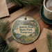 A round ornament with a scenic image of Norris Dam State Park, Tennessee, hanging on a wooden surface.