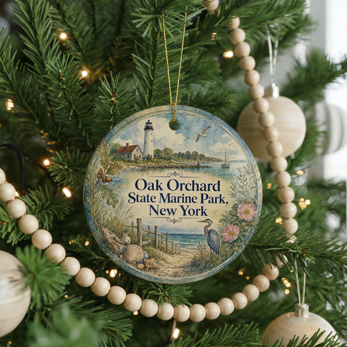 A round ornament hanging on a Christmas tree, featuring a lighthouse and a seagull, with the text "Oak Orchard State Marine Park, New York" displayed on it.