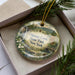 A decorative ornament in a box, featuring a scenic landscape with a waterfall and pine trees, with the text "Oquaga Creek State Park, New York" prominently displayed.