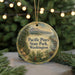 A round ornament with a scenic landscape of Pacific Pines State Park, Washington, featuring a mountain, pine trees, and a bird.
