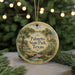 A round ornament with a scenic image of palm trees and a house, surrounded by greenery, hangs in front of a blurred background with twinkling lights.