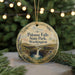 A round ornament with a scenic image of Palouse Falls State Park, Washington, hanging from a string.