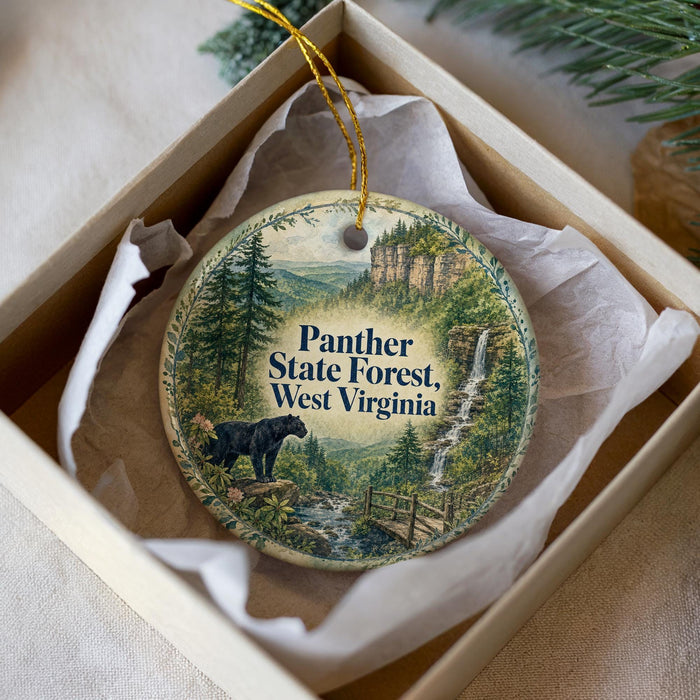 A decorative ornament in a box, featuring a scenic image of the Panther State Forest in West Virginia.