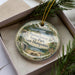 A decorative ornament in a box, featuring a scenic image of Pawtucket State Park in New Hampshire.