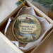 A decorative ornament in a box, featuring a scenic landscape with mountains, trees, and a bird, along with the text "Pearrygin Lake State Park, Washington".