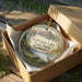 A decorative ornament in a wooden box, featuring a scenic landscape with mountains, trees, and a bird, along with the text "Pearry Lake State Park, Washington".